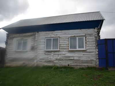 Деревянный жилой дом с обильной пропильной резьбой по карнизам и наличниками