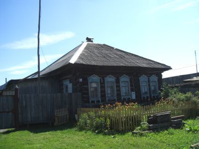 Деревянный дом Басалаевых конца XIX века с обильной пропильной резьбой по двуслойному карнизу и наличникам