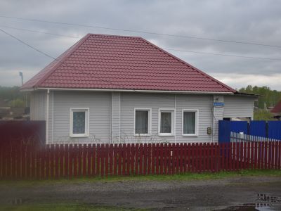 Деревянный жилой дом конца XIX века - начала XX века с обильной пропильной резьбой по карнизам и наличниками