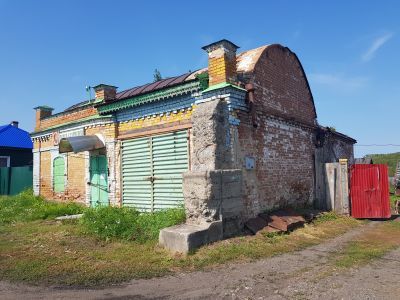 Каменное здание конца ХVIII века с рельефами по фасаду, имитирующими деревянные резные декоры, с фигурными коваными воротами, бывший торговый дом