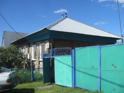 Деревянный дом начала XX века с глухой резьбой по наличникам и пропильным карнизом, ныне правление колхоза "Труд новой жизни"