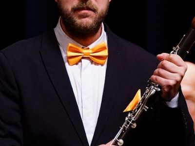 Высокий блондин с кларнетом и оркестром