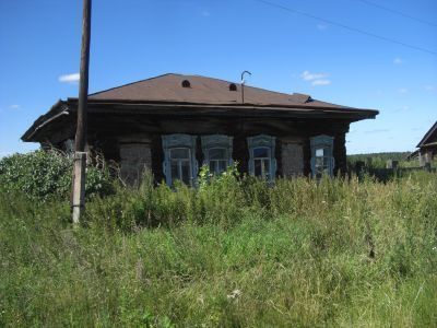 Деревянный жилой дом начала XX века с сохранившимися воротами, украшенными высокохудожественной глухой, пропильной резьбой по наличникам и карнизам