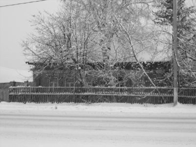 Деревянный жилой дом конца XIX века начала XX века с обильной пропильной резьбой по карнизам и наличниками