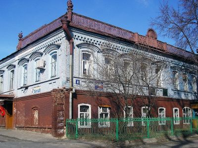 Дом в кирпичном исполнении с ажурными металлическими карнизами