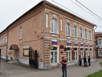 Двухэтажное каменное здание конца XIX века с декором из тесанного кирпича, имитирующим деревянный декор, с оконными решетками высокохудожествнного литья, бывшая типография Прейсмана, ныне Госбанк.