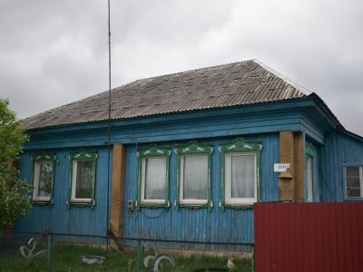 Деревянный жилой дом конца XIX века начала XX века с обильной пропильной резьбой по карнизам и наличниками