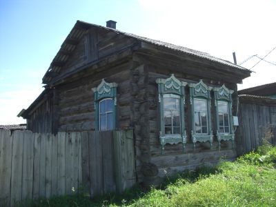 Деревянный жилой дом начала XX века с сохранившимися воротами, украшенными высокохудожественной глухой, пропильной резьбой по наличникам и карнизам