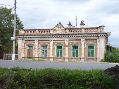 Одноэтажное каменное здание с декоративным парапетом, богато украшенное каменной резьбой