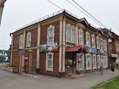 Двухэтажное деревянное здание начала XX века с двумя фронтонами, украшенными обильной пропильной резьбой по карнизу, с наличниками, с решетками художественного литья в цокольном этаже, ныне художественная школа