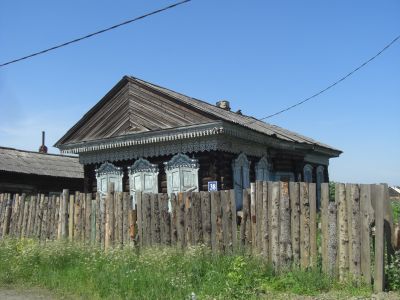 Деревянный жилой дом конца XIX века с трехслойным резным карнизом и накладным декором на четырех фронтонах