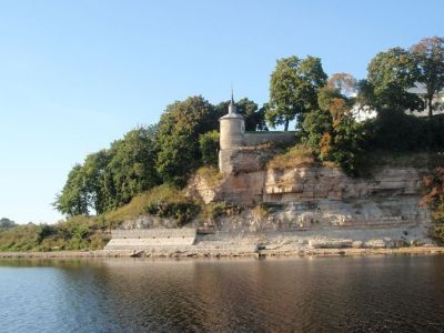 Каменная ограда монастыря с башней на берегу реки Великой и часовня