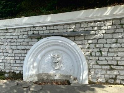 Подпорная стена в северо-восточном направлении с арочной нишей, украшенной маскароном льва, формирующая въездную группу на территорию санатория «Кудепста»