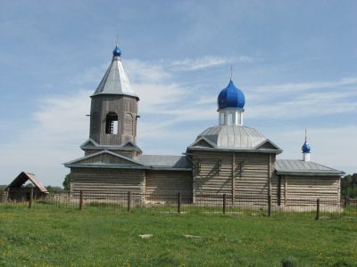 Деревянная церковь середины XIX века, под куполами с кованными оконными решетками и крестами высокохудожественного литья, ныне зерносклад