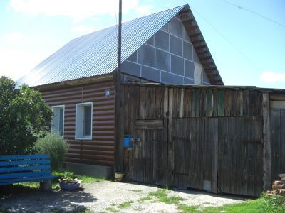 Деревянный жилой дом начала XX века с сохранившимися воротами, украшенными высокохудожественной глухой, пропильной резьбой по наличникам и карнизам