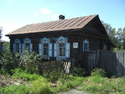 Деревянный жилой дом конца XIX века со своеобразным резным декором на мотив "солнышко" по фронтону и пропильной резьбой карнизов