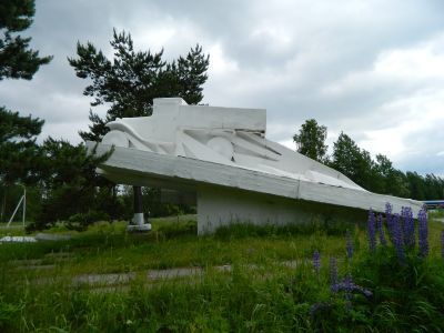 Памятник-автомашина в честь автомобилистов, работавших на «Дороге жизни», проходившей здесь в 1941-1943 гг. Рядом-место захоронения неизвестного шофера, погибшего в годы войны