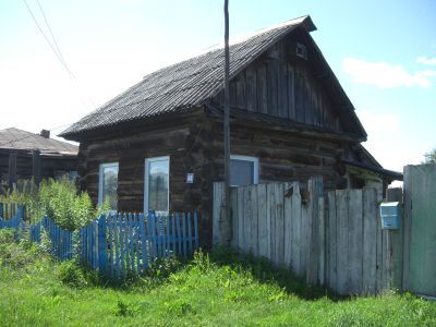 Деревянный жилой дом начала XX века с сохранившимися воротами, украшенными высокохудожественной глухой, пропильной резьбой по наличникам и карнизам