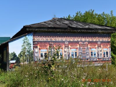 Деревянный жилой дом конца XIX века с глухой и пропильной резьбой карнизов, наличников и воротами с оригинальным декором «солнышко»