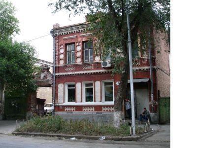 Двухэтажный жилой дом с кирпичной аркой ворот