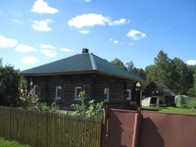 Деревянный жилой дом конца XIX века со своеобразным резным декором на мотив "солнышко" по фронтону и пропильной резьбой карнизов