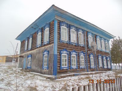 Деревянный двухэтажный "учительский" дом начала XX века, перевезен в 50-х годах из д. Алаево, где служил школой, с обильным пропильным декором наличников и многослойных карнизов