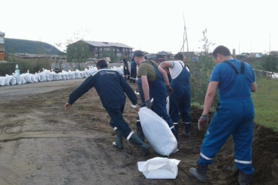 Более 80 человек и 10 единиц техники задействованы в работах по укреплению дамбы в Батагае /    